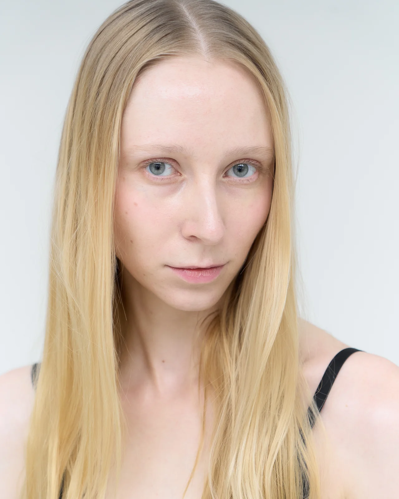 Close-up portrait of the model looking straight into the camera with a calm, focused gaze